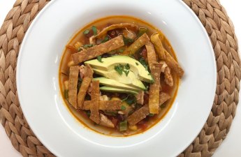 Spicy Chicken Tortilla Soup topped with homemade baked tortilla strips, avocado, and cilantro. | thetopknotkitchen.com #thetopknotkitchen #spicy #chickentortillasoup #soup